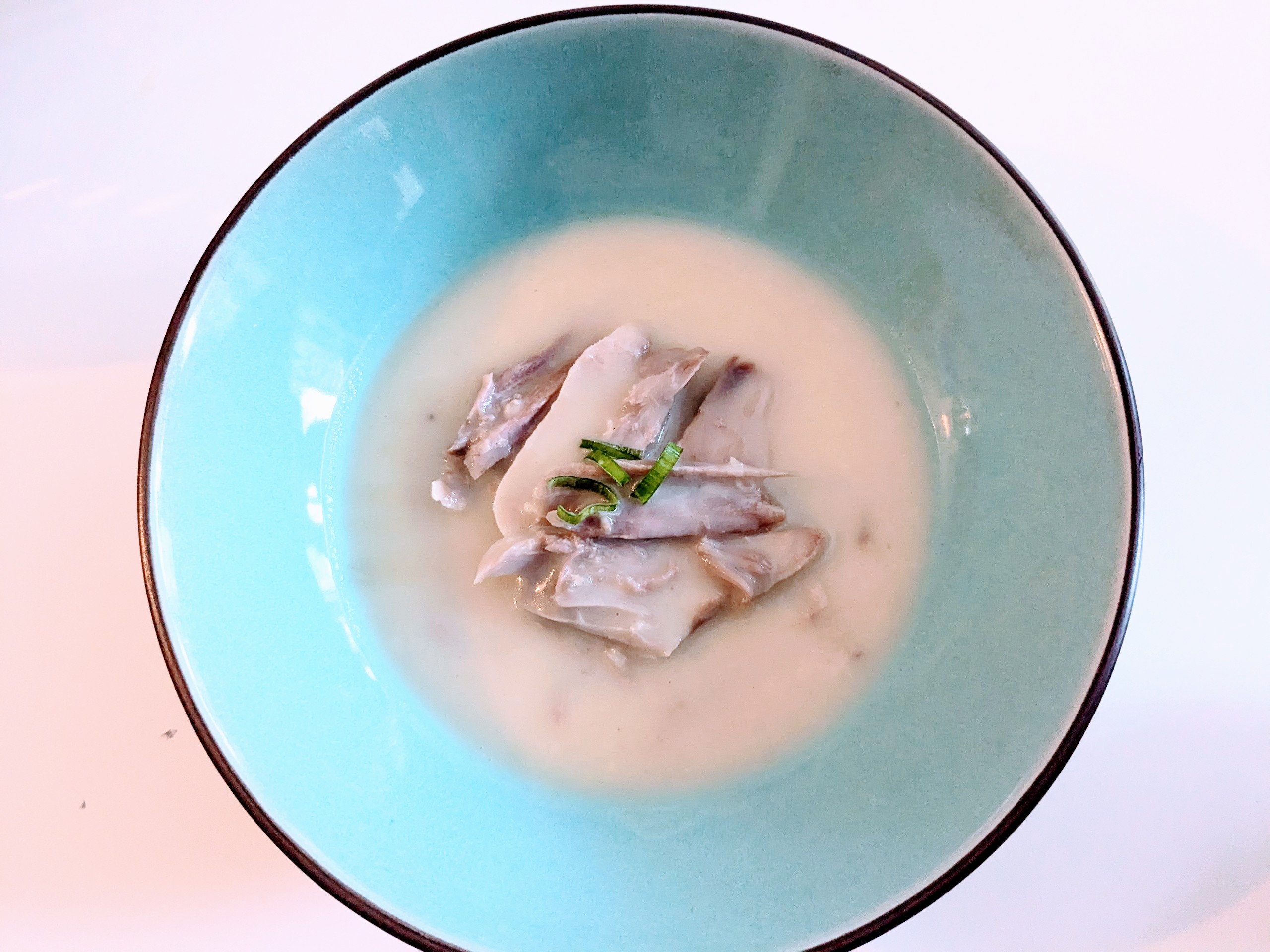 Photo d'une assiette contenant des morceaux de poule au pot et de la sauce